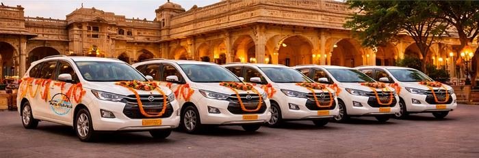 Six garlanded wedding cars lined up outside a Jaipur heritage venue